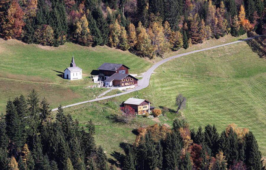 Luftbild der Benediktskapelle und landwirtschaftlicher Gebäude im Ortsteil Bischa von Dünserberg