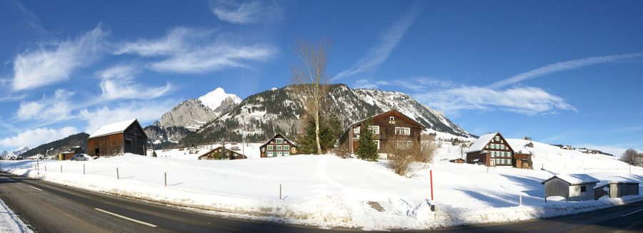 Panorama of a district of Wildhaus in the Toggenburg region, with the snow-covered Schafberg in the background