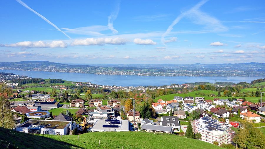 Blick auf Schindellegi beziehungsweise Feusisberg und Wollerau mit dem Zürichsee und der umliegenden Landschaft im Hintergrund