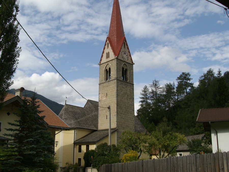 Außenansicht der Pfarrkirche St. Oswald in Mauls mit markantem Steinturm