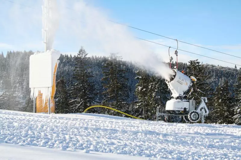 Snow cannon operating on a snowy ski slope